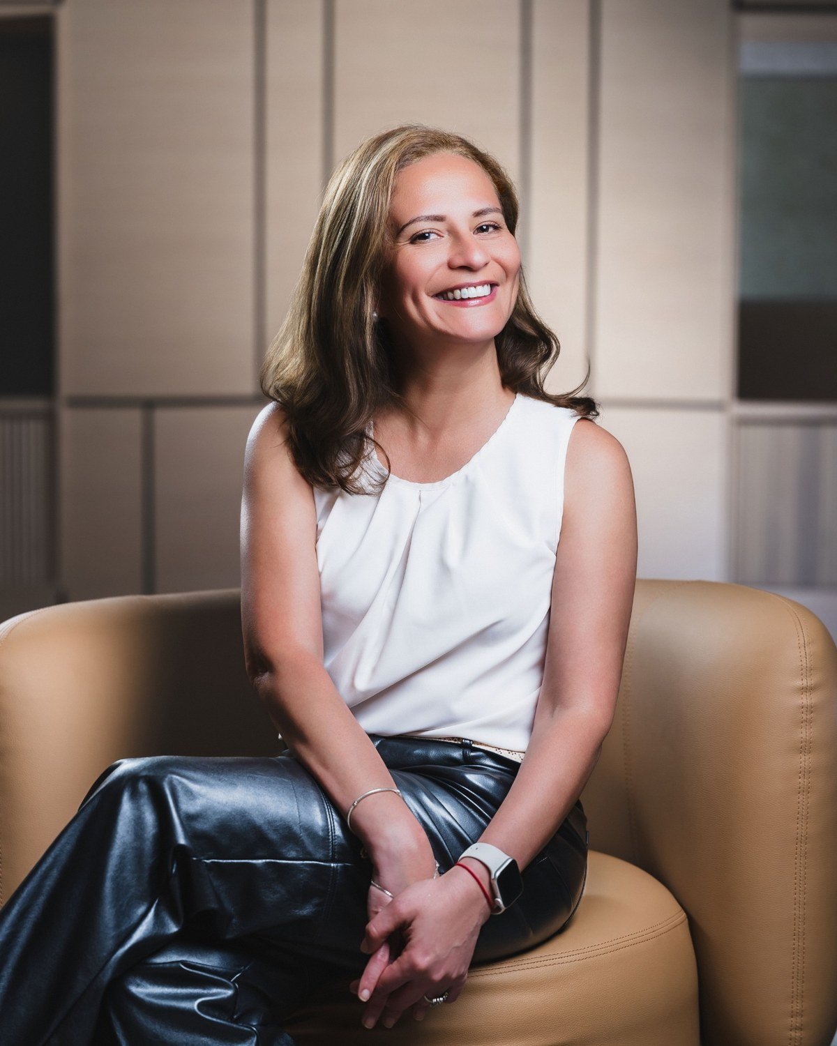 Maria Fernanda Crespo seated in a contemporary interior, smiling at the camera